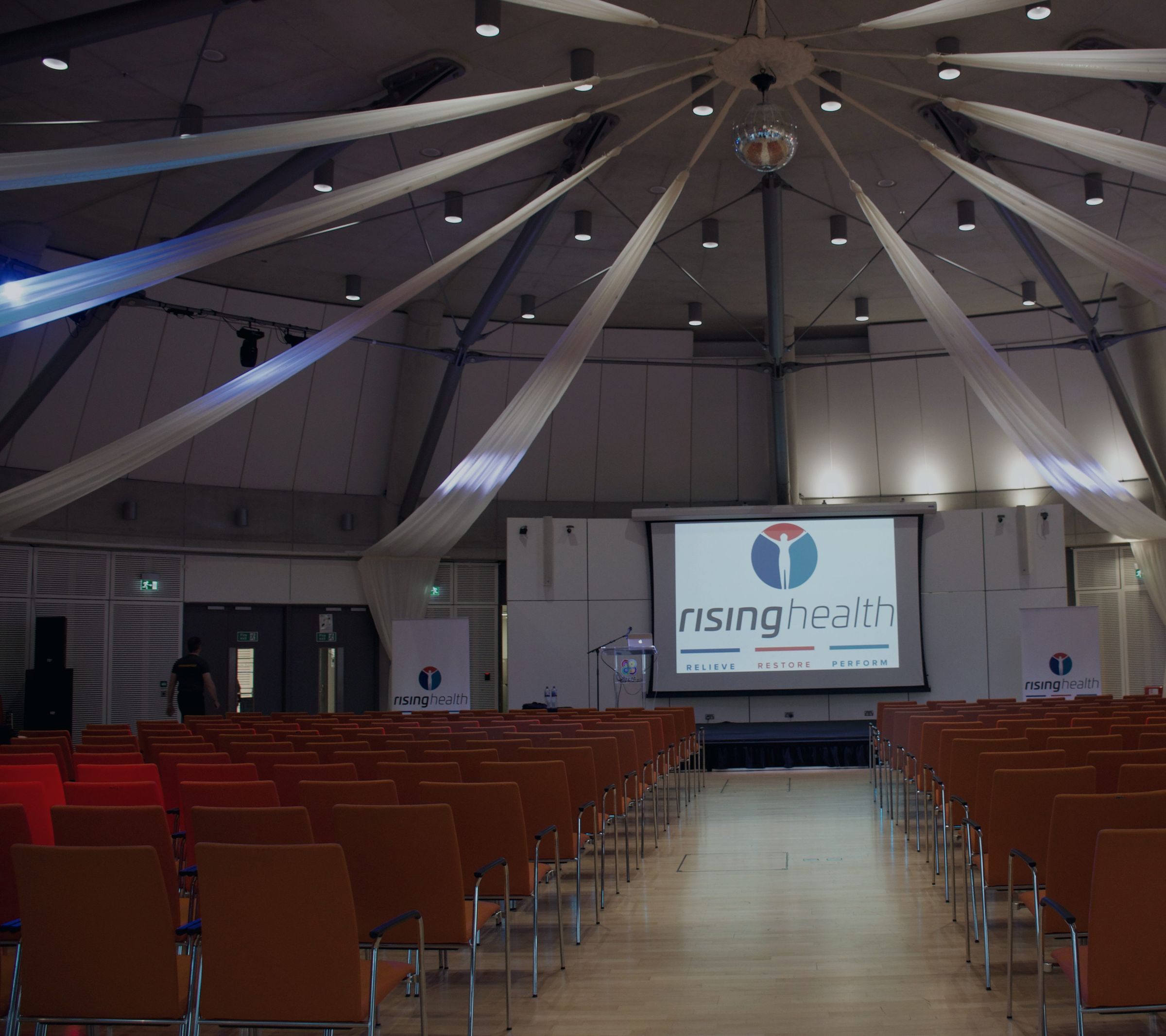 A Rising Health corporate wellbeing event, with the Rising Health logo on the main screen